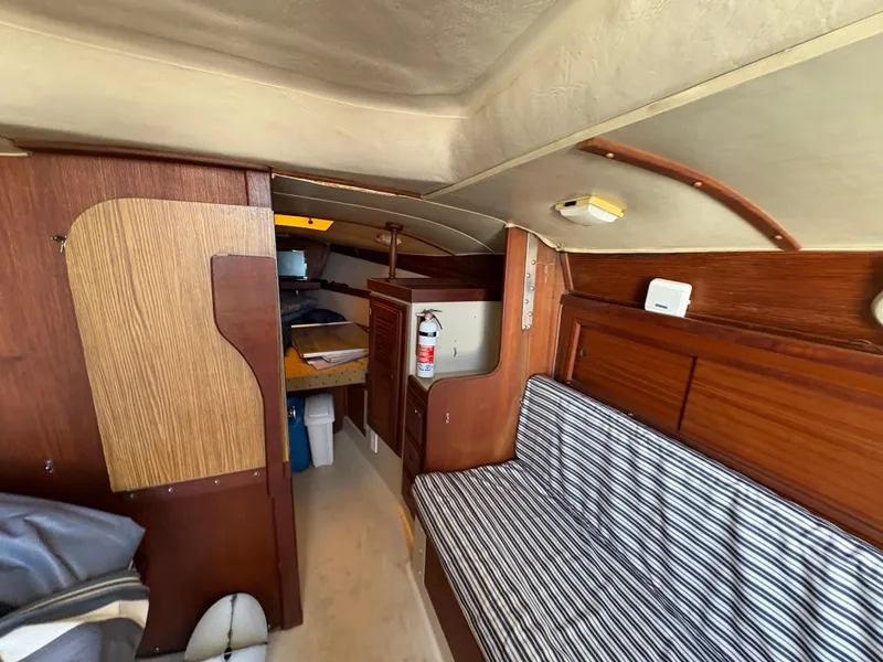 Slide: The Image of Interior of 1981 Newport 27 S sailboat with striped seating and wooden cabinetry. - 31