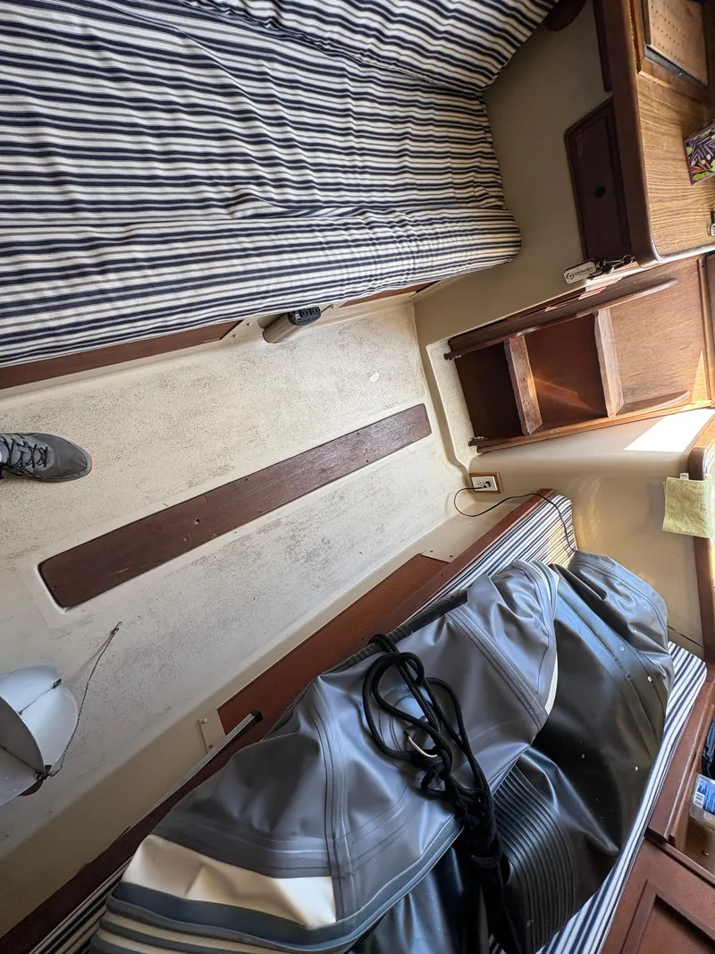 Slide: The Image of Interior of 1981 Newport 27 S sailboat with striped cushions and wooden cabinetry. - 39