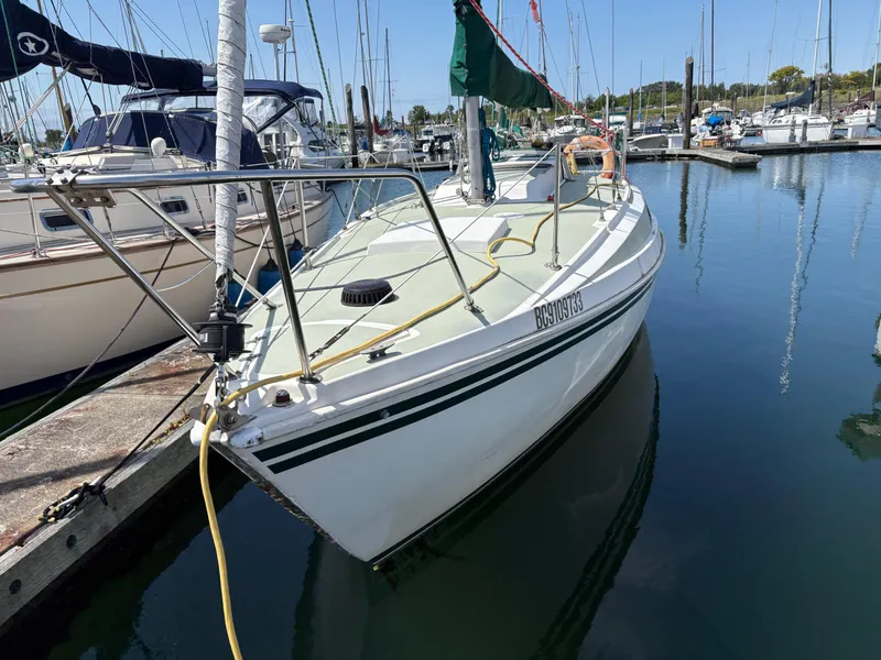 Slide: The Image of 1981 Newport 27 S sailboat docked in a marina, surrounded by other boats. - 4
