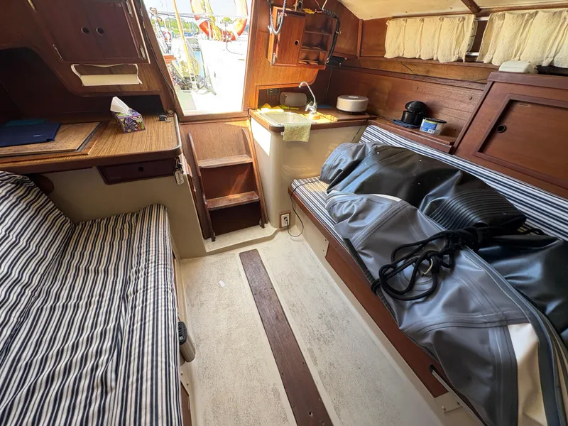 Slide: The Image of Interior of 1981 Newport 27 S sailboat with striped seating and wooden cabinetry. - 40