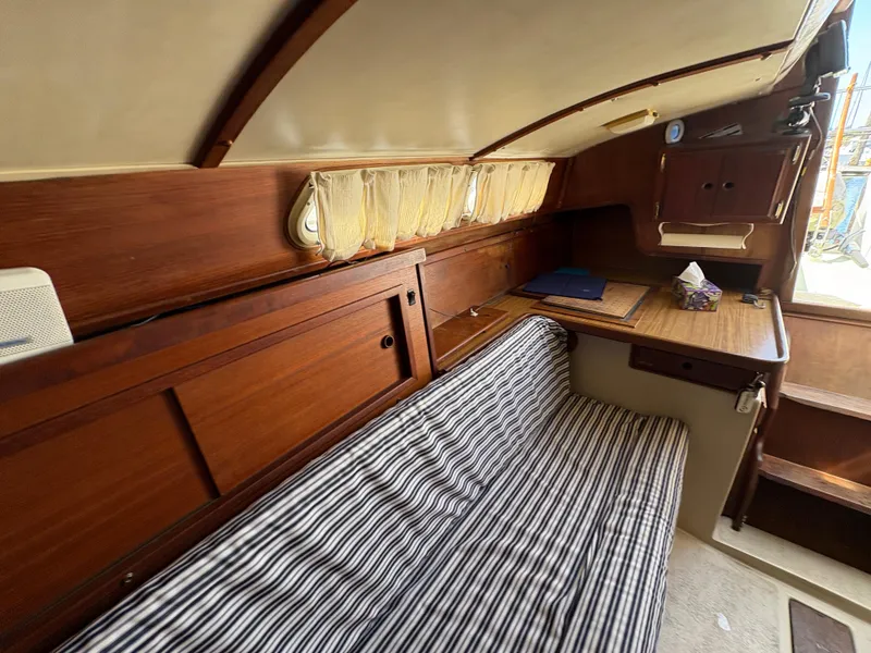Slide: The Image of Interior of 1981 Newport 27 S sailboat with striped seating and wooden cabinetry. - 43