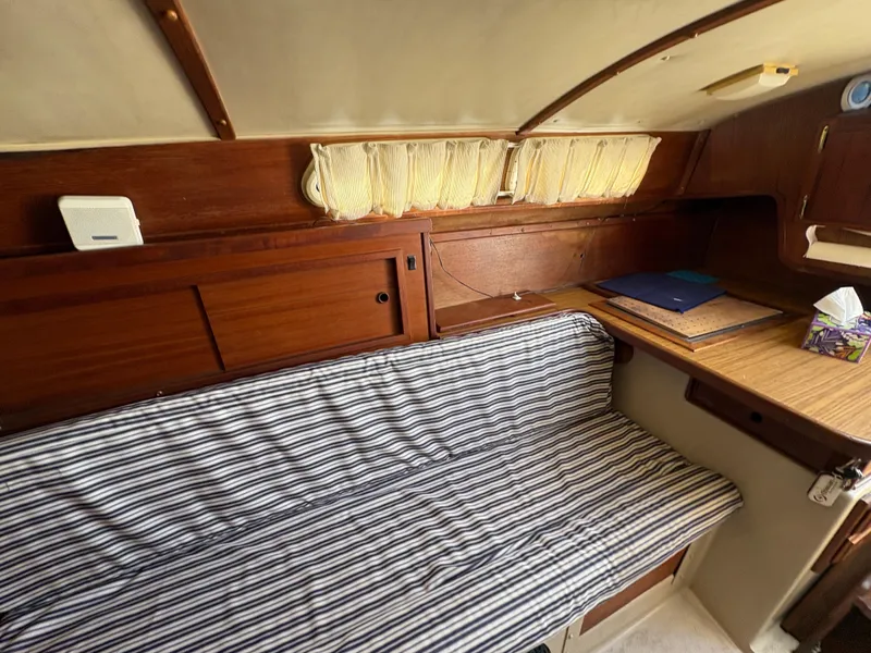 Slide: The Image of Interior of 1981 Newport 27 S sailboat with striped seating and wooden cabinetry. - 44