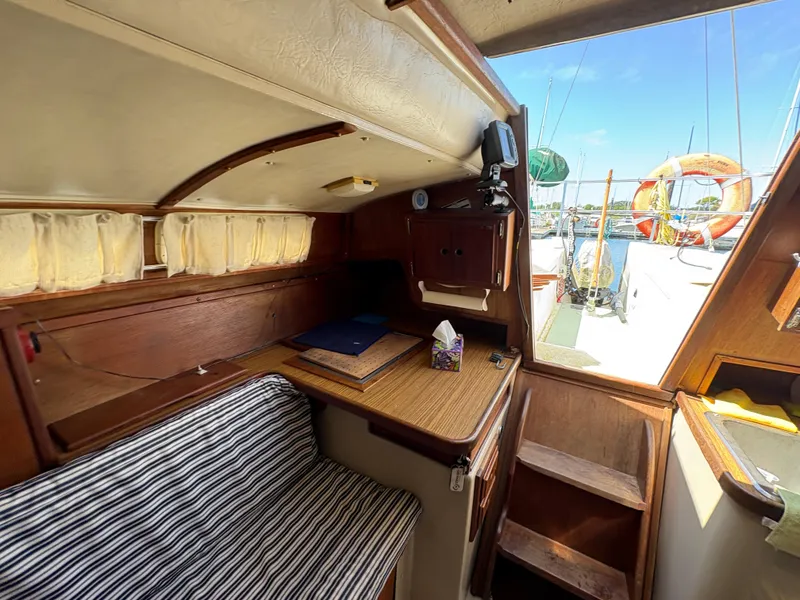 Slide: The Image of Interior of 1981 Newport 27 S sailboat with wooden table and striped seating. - 45
