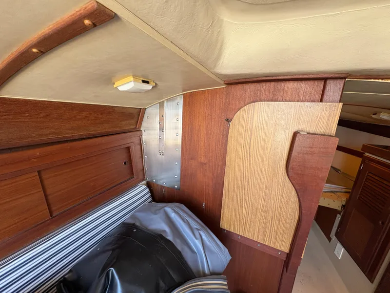 Slide: The Image of Interior of 1981 Newport 27 S sailboat with wood paneling and striped upholstery. - 46