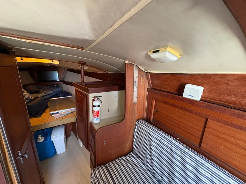 Slide: The Image of Interior of 1981 Newport 27 S sailboat with striped seating and wooden cabinetry. - 47