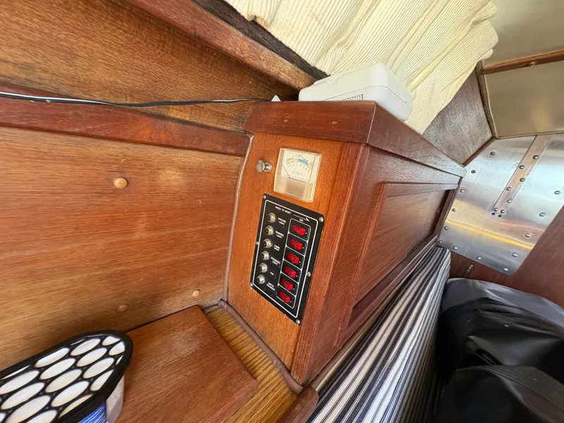 Slide: The Image of 1981 Newport 27 S interior with wooden paneling and control switches. - 49