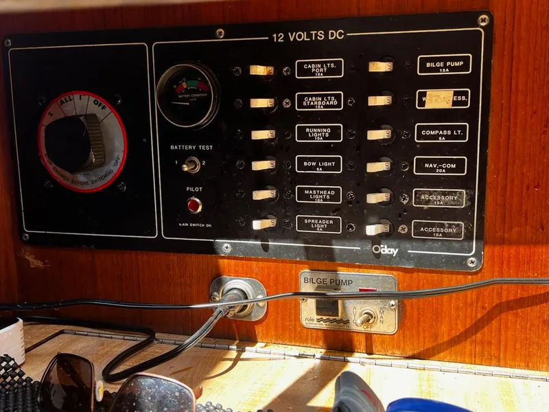 Slide: The Image of 1982 O'Day 28 sailboat electrical panel with switches and battery test gauge. - 12