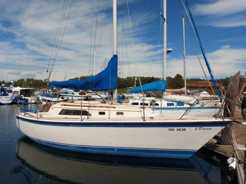 Slide: The Image of 1982 O'Day 28 sailboat docked in a marina, featuring blue sails and clear skies. - 2