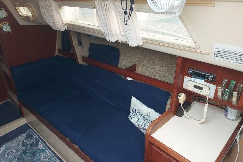 Slide: The Image of Interior of a 1982 O'Day 28 sailboat with blue seating and nautical decor. - 24