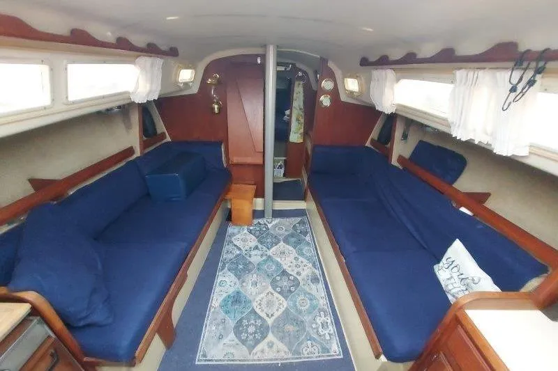 Slide: The Image of Interior of a 1982 O'Day 28 sailboat with blue seating and patterned rug. - 26