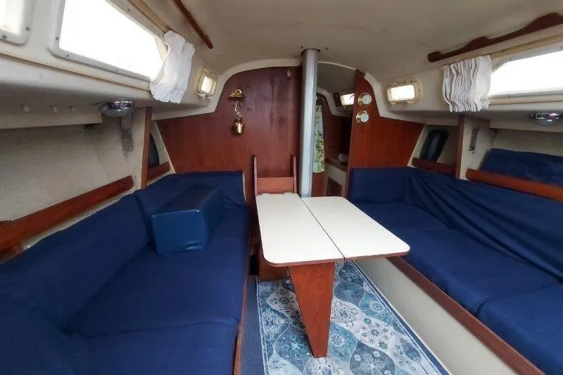Slide: The Image of Interior of a 1982 O'Day 28 sailboat with blue seating and wooden accents. - 30