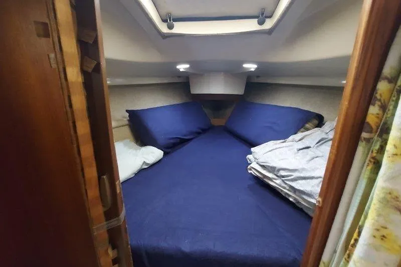 Slide: The Image of Cozy cabin interior of 1982 O'Day 28 sailboat with blue bedding and overhead lighting. - 31