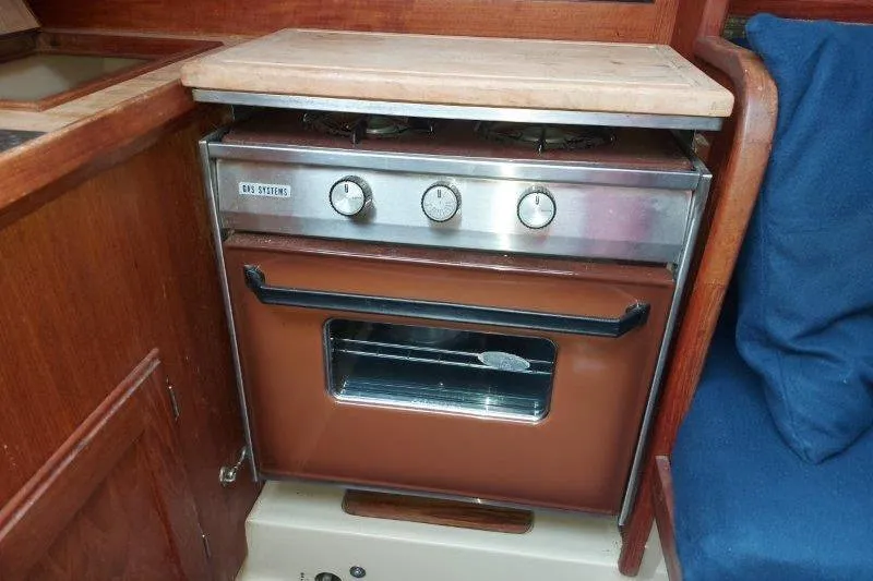 Slide: The Image of 1982 O'Day 28 sailboat interior with a compact gas stove and oven. - 38