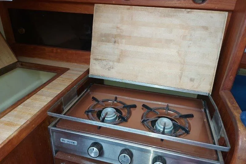 Slide: The Image of 1982 O'Day 28 sailboat interior with a two-burner stove and wooden countertop. - 39