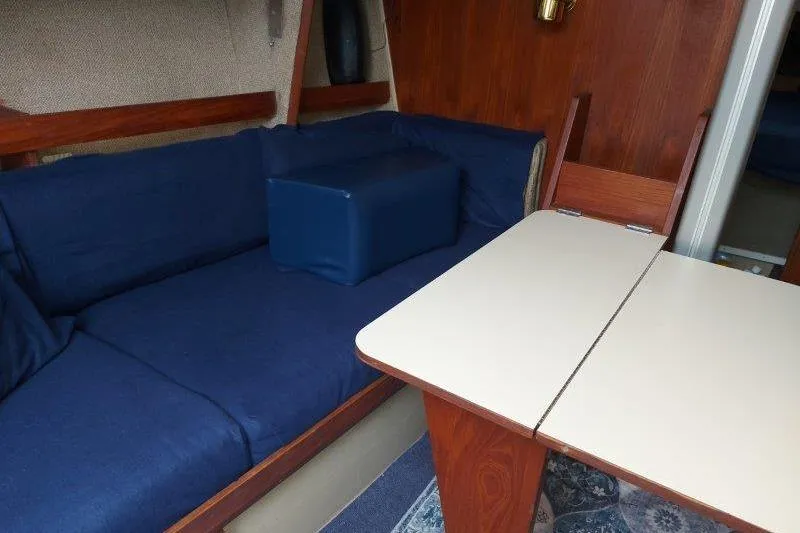 Slide: The Image of Interior of 1982 O'Day 28 sailboat with blue seating and foldable table. - 42