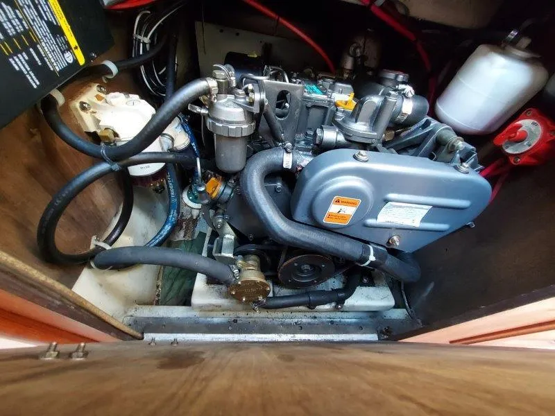 Slide: The Image of Engine compartment of a 1982 O'Day 28 sailboat, showcasing mechanical components and hoses. - 46