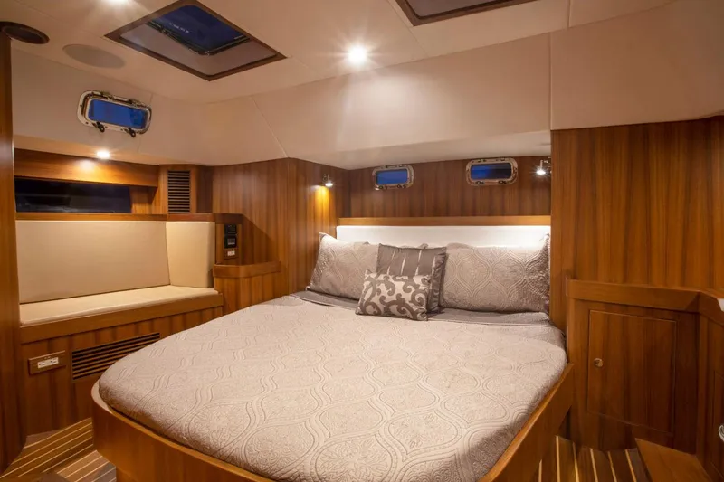 Slide: The Image of Manufacturer Provided Image: Luxurious cabin interior of 2025 Hylas H48 yacht with wood paneling and cozy bedding. - 12