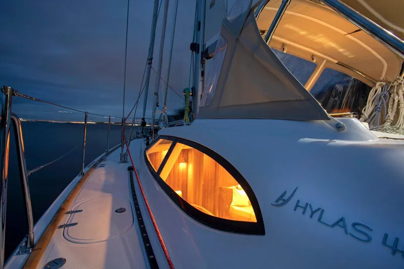 Slide: The Image of Manufacturer Provided Image: 2025 Hylas H48 yacht at dusk, illuminated cabin, sleek design. - 4