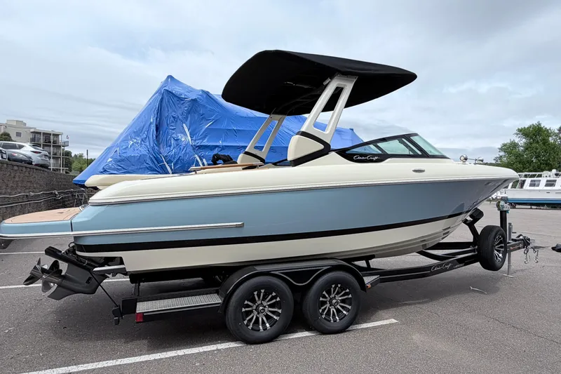Slide: The Image of 2026 Chris-Craft Sportster 25 boat on trailer, parked outdoors. - 2