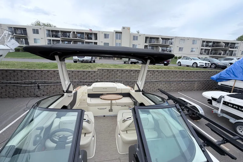 Slide: The Image of 2026 Chris-Craft Sportster 25 boat with sleek design, parked near residential buildings. - 21
