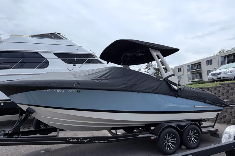 Slide: The Image of 2026 Chris-Craft Sportster 25 boat on trailer, covered, parked near buildings. - 33