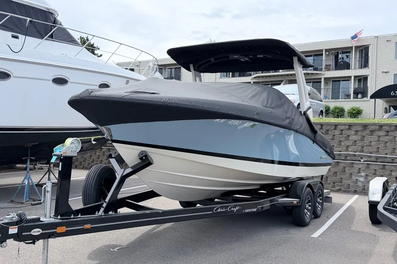 Slide: The Image of 2026 Chris-Craft Sportster 25 boat on trailer, covered, parked in marina lot. - 34