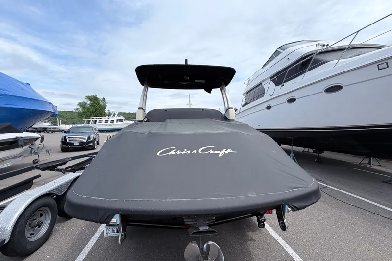Slide: The Image of 2026 Chris-Craft Sportster 25 boat covered, parked in marina with other boats. - 35