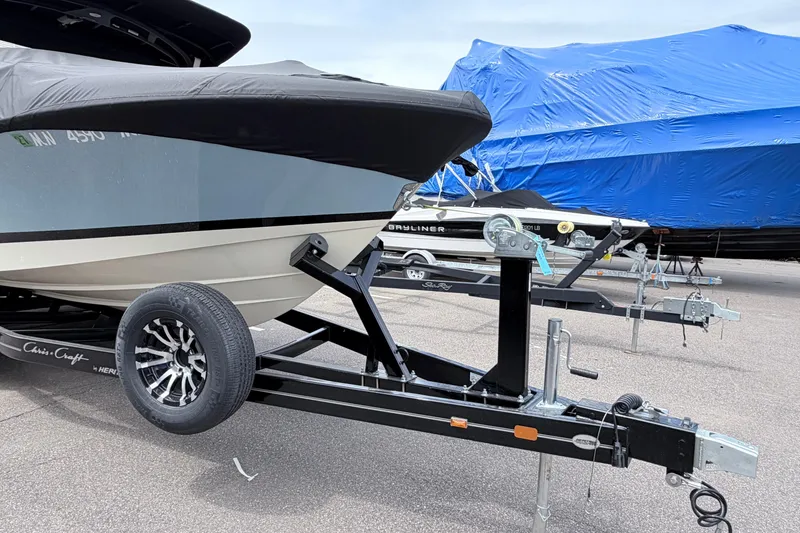 Slide: The Image of 2026 Chris-Craft Sportster 25 boat on trailer, covered and parked outdoors. - 36