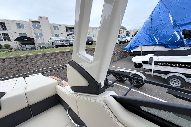 Slide: The Image of 2026 Chris-Craft Sportster 25 boat interior with nearby parked vehicles and covered boat. - 39