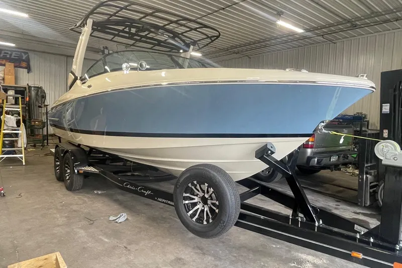 Slide: The Image of 2026 Chris-Craft Sportster 25 boat in a garage on trailer. - 45
