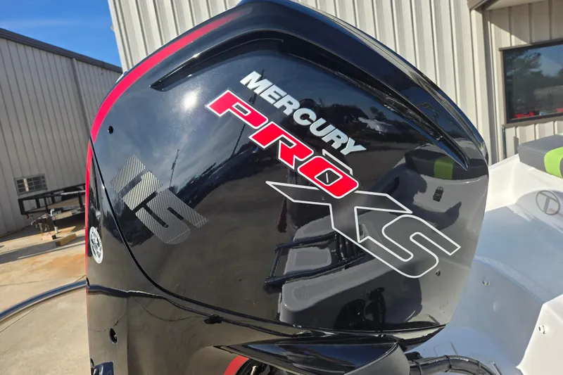 Slide: The Image of 2023 Tahoe T18 with Mercury Pro XS outboard motor, parked near a building. - 10