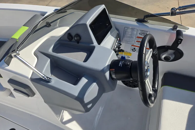 Slide: The Image of 2023 Tahoe T18 boat dashboard with steering wheel and control panel. - 12