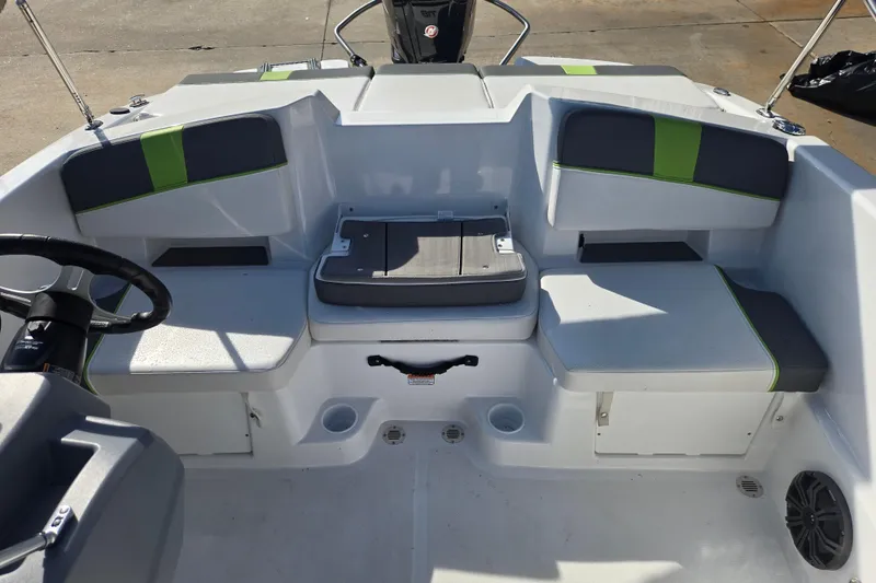 Slide: The Image of 2023 Tahoe T18 boat interior with gray and green seating, steering wheel, and storage compartments. - 16