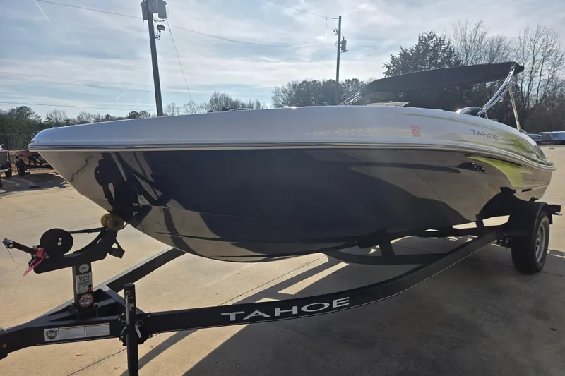 Slide: The Image of 2023 Tahoe T18 boat on trailer, parked outdoors under clear sky. - 9