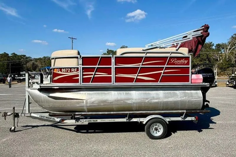 The Image of 2017 Bentley Pontoons 140 Cruise on trailer, red and beige design, parked outdoors. - 0