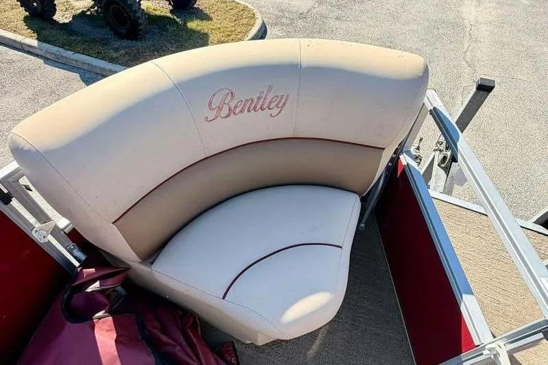 Slide: The Image of 2017 Bentley Pontoons 140 Cruise, beige seating with red accents, outdoor setting. - 11