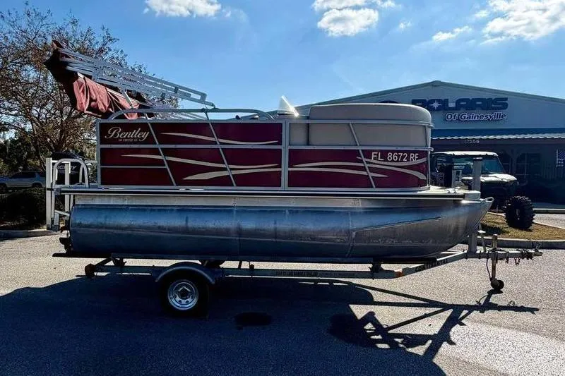 Slide: The Image of 2017 Bentley Pontoons 140 Cruise on trailer, parked outdoors under a clear sky. - 4