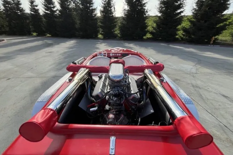 Slide: The Image of 1975 Weirdt Maverick with exposed engine and red interior, parked outdoors. - 11