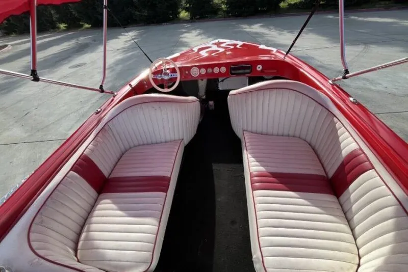 Slide: The Image of 1975 Weirdt Maverick boat interior with red and white seating, classic steering wheel, and dashboard. - 22