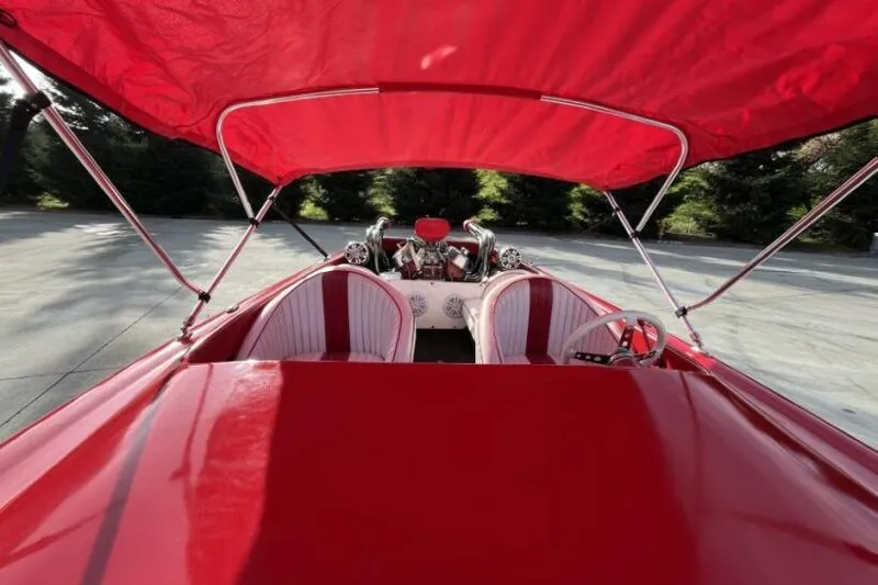 Slide: The Image of Red 1975 Weirdt Maverick boat with canopy, featuring dual seats and visible engine. - 24