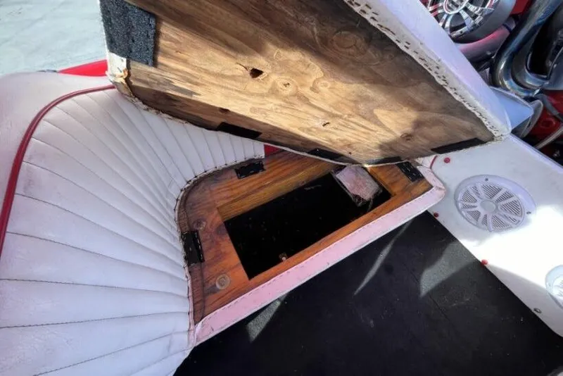 Slide: The Image of Interior of a 1975 Weirdt Maverick with open wooden storage compartment under white seat. - 33