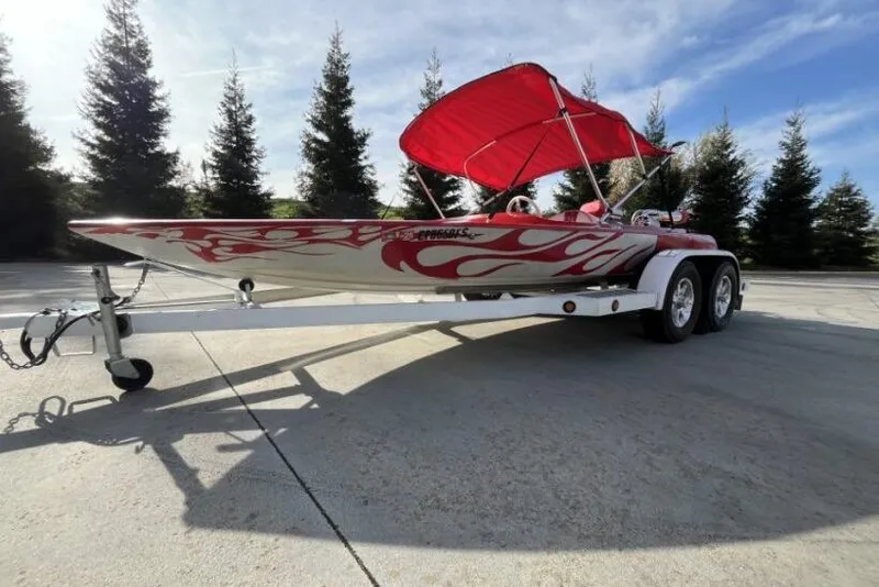 Slide: The Image of 1975 Weirdt Maverick speedboat with red flame design and canopy on trailer. - 5