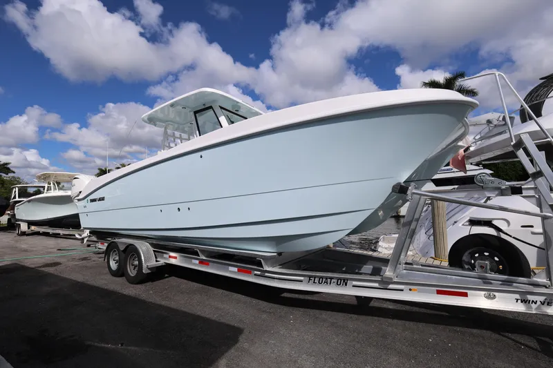 Slide: The Image of 2025 Twin Vee 280 GFX2 CC boat on trailer under blue sky. - 1