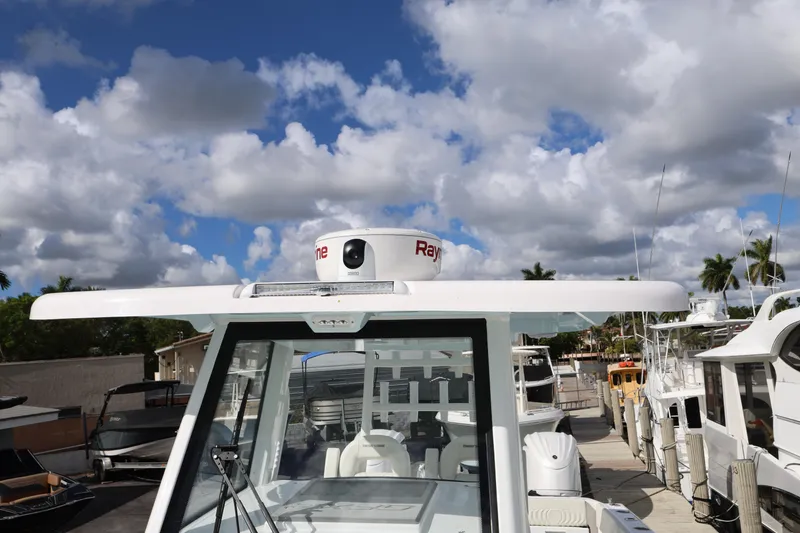 Slide: The Image of 2025 Twin Vee 280 GFX2 CC boat docked under a partly cloudy sky. - 13