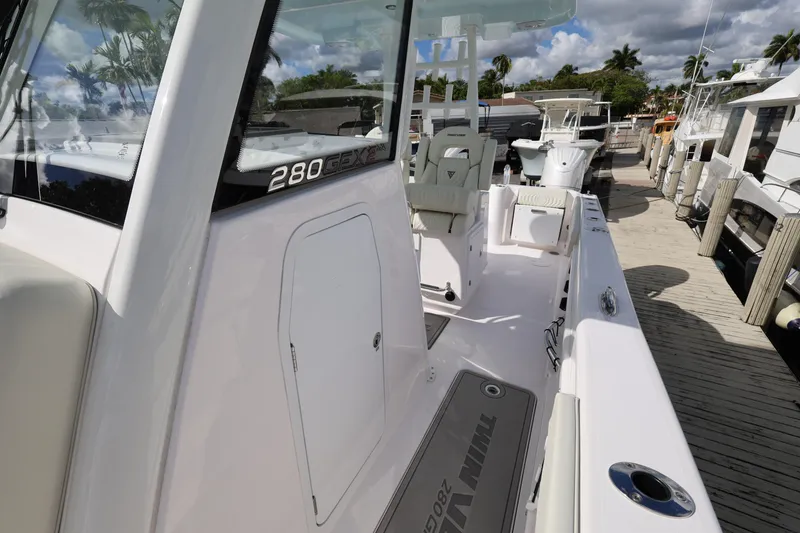 Slide: The Image of 2025 Twin Vee 280 GFX2 CC boat docked, showcasing sleek design and spacious deck. - 14