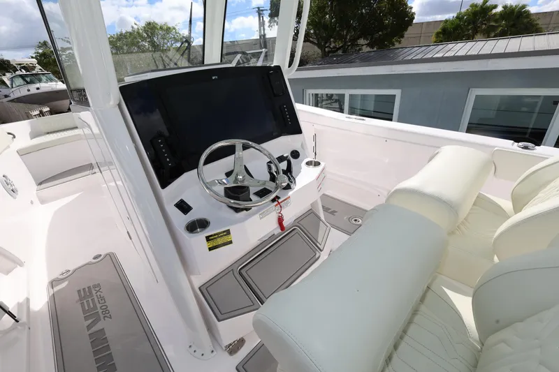 Slide: The Image of 2025 Twin Vee 280 GFX2 CC boat cockpit with steering wheel and modern controls. - 18