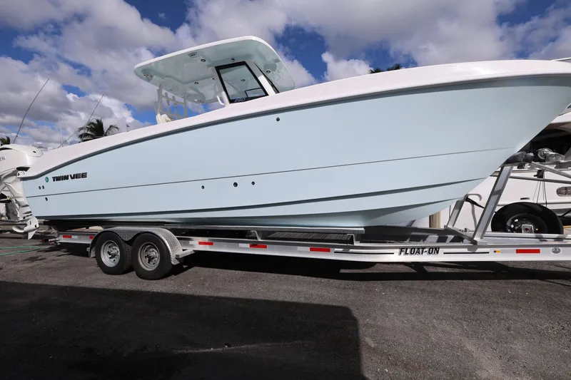 Slide: The Image of 2025 Twin Vee 280 GFX2 CC boat on trailer under a cloudy sky. - 2