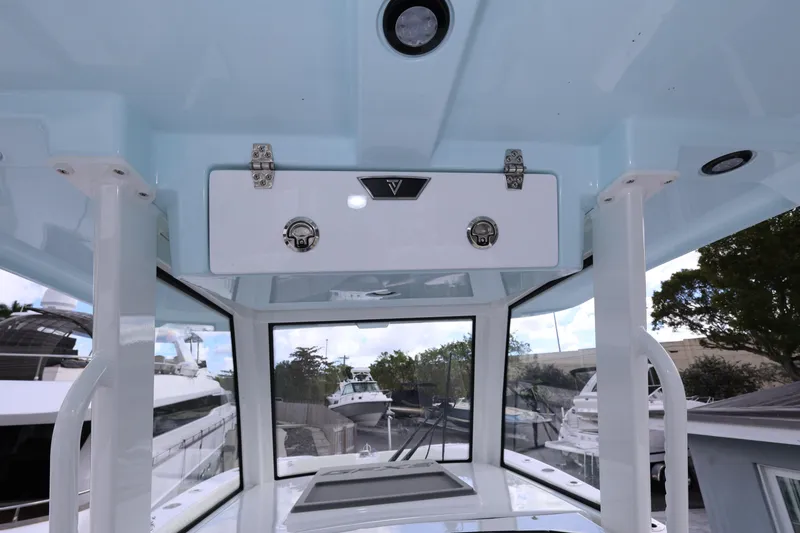 Slide: The Image of 2025 Twin Vee 280 GFX2 CC boat interior, featuring a sleek console and storage compartment. - 20