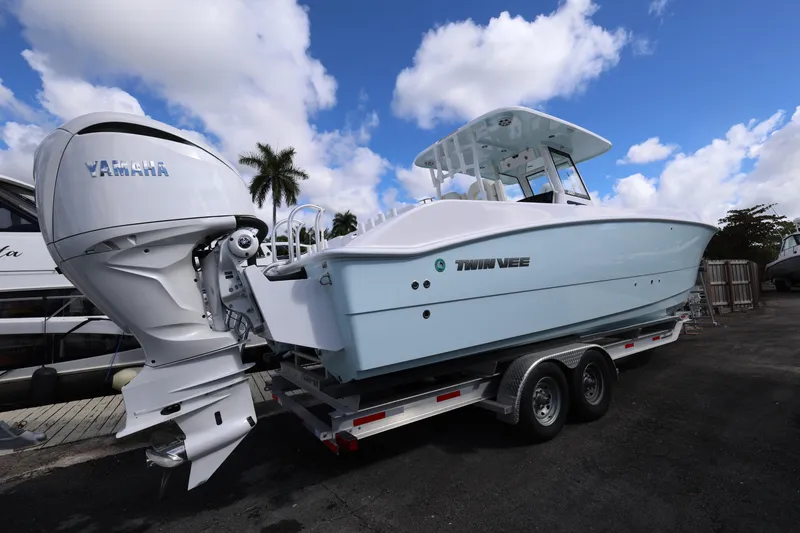Slide: The Image of 2025 Twin Vee 280 GFX2 CC boat on trailer with Yamaha engine, under blue sky. - 4