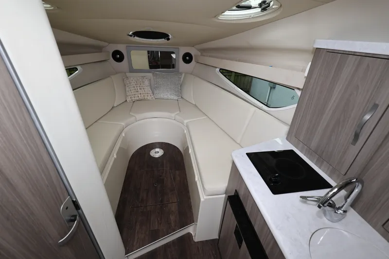Slide: The Image of 2021 Regal 28 Express boat interior with cozy seating and compact kitchenette. - 21